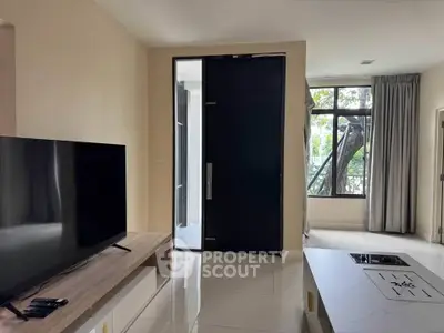 Modern living room with sleek TV setup and large window view