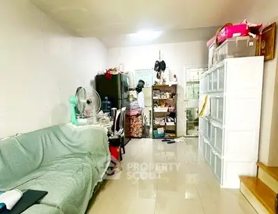 Cozy living room with tiled floor, sofa, and ample storage space.