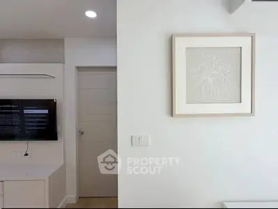 Modern living room with minimalist decor and wall-mounted TV in a stylish apartment.