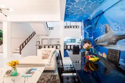 Stunning open-plan living room with unique ocean-themed wall art and modern furnishings.