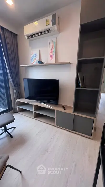 Modern living room with sleek TV unit and air conditioning, perfect for cozy relaxation.
