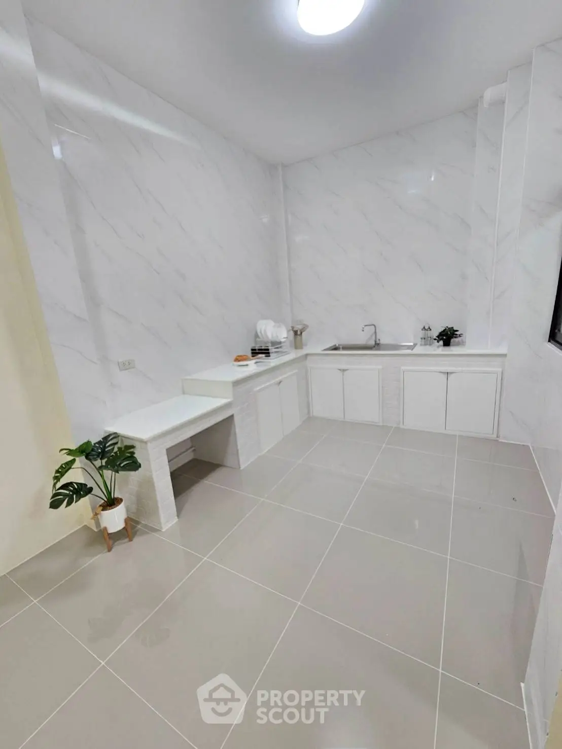 Spacious modern kitchen with sleek white cabinetry and elegant marble walls