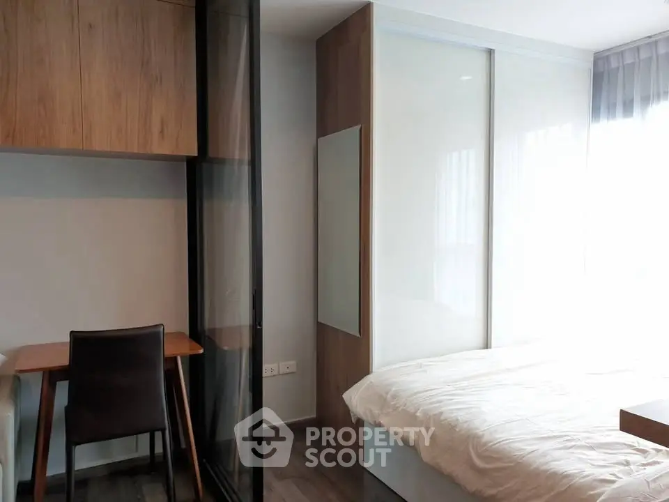 Modern bedroom with sleek design, featuring a cozy bed and stylish workspace.