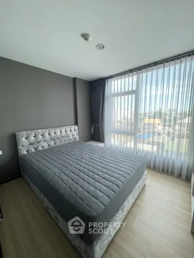 Spacious bedroom with large window and modern decor