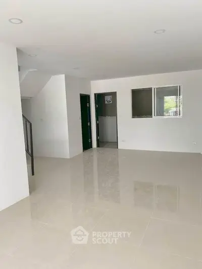 Spacious open-plan living area with modern minimalist design and glossy tile flooring.