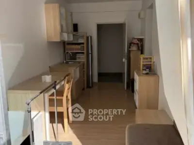 Cozy kitchen with wooden cabinets and modern appliances in a compact apartment setting.