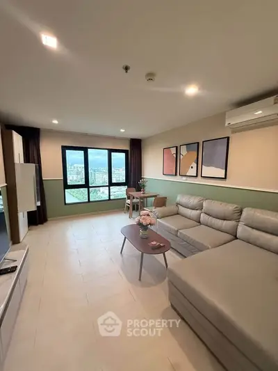 Spacious living room with modern decor and large window offering city views.