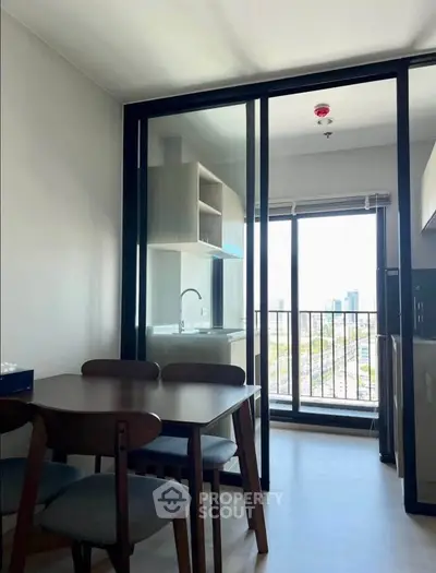 Modern dining area with glass doors leading to a balcony with city view