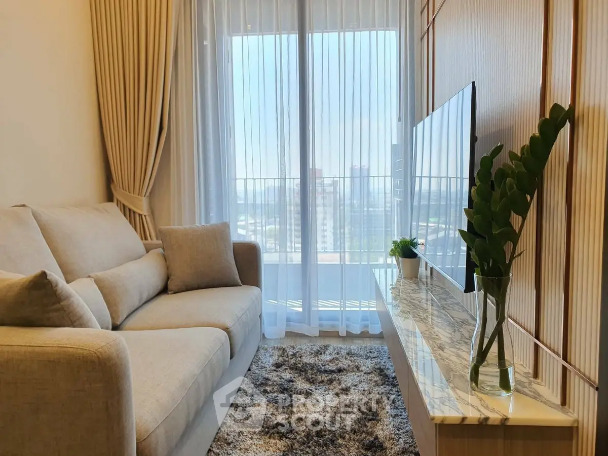 Cozy living room with plush sofa, stylish decor, and large window offering a scenic view.