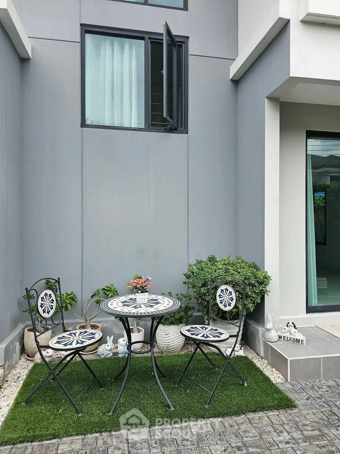 Charming outdoor patio with stylish furniture and lush greenery, perfect for relaxation and entertaining.
