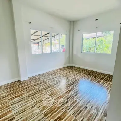 Spacious room with large windows and wood-patterned tile flooring