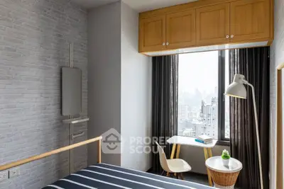 Modern bedroom with city view, featuring stylish furniture and natural light.