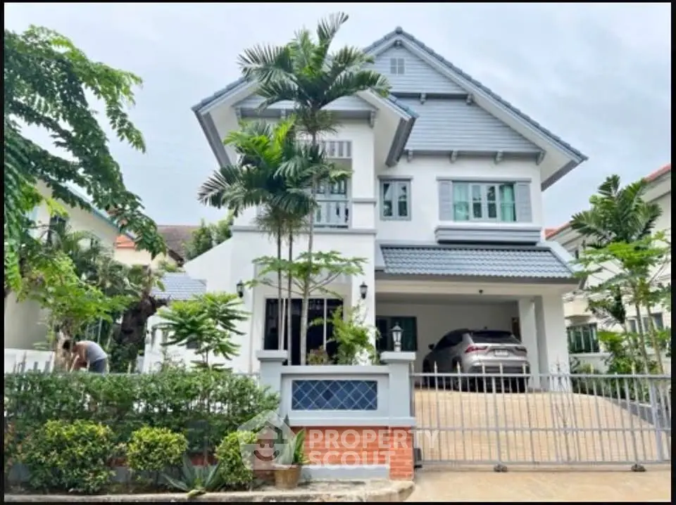 Charming two-story house with lush garden and spacious driveway in a serene neighborhood.