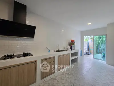 Modern kitchen with sleek design, featuring gas stove and ample natural light.