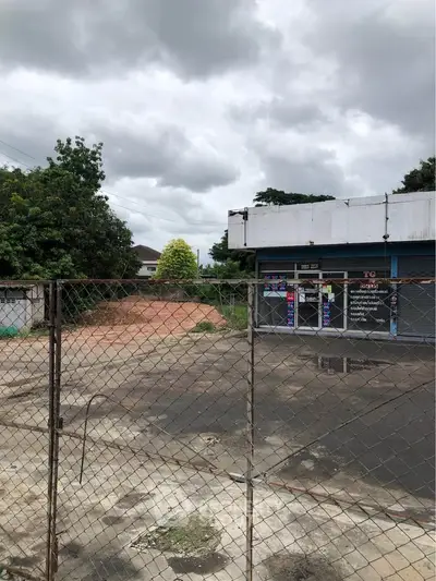 Commercial property with fenced yard and cloudy sky backdrop