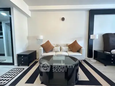 Modern living room with stylish black and white decor and cozy seating area.