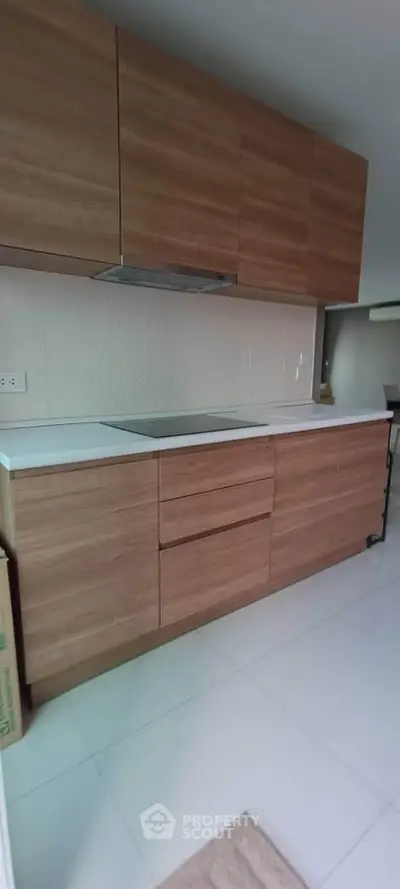 Modern kitchen with sleek wooden cabinets and white countertops
