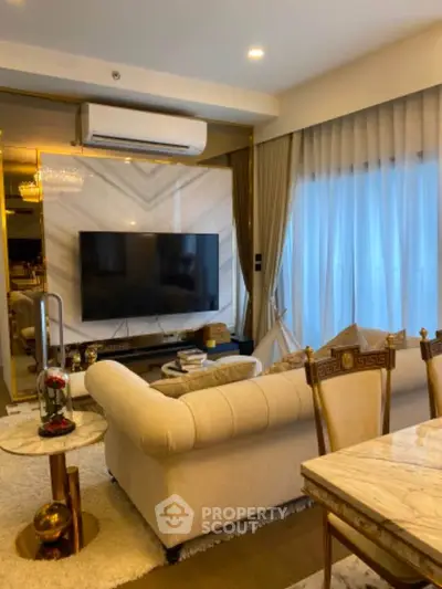 Luxurious living room with elegant decor, plush sofa, and large TV, perfect for relaxation and entertainment.