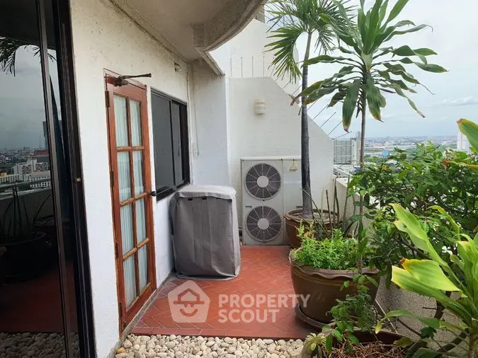 Spacious high-rise balcony with lush potted plants offering a panoramic city view, ideal for relaxation and urban gardening.