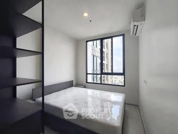 Modern minimalist bedroom with large window and city view