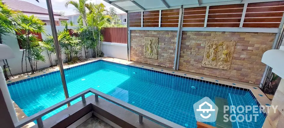 Luxurious private pool with elegant stone wall and tropical landscaping