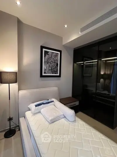 Modern bedroom with stylish decor and mirrored wardrobe in a cozy apartment.