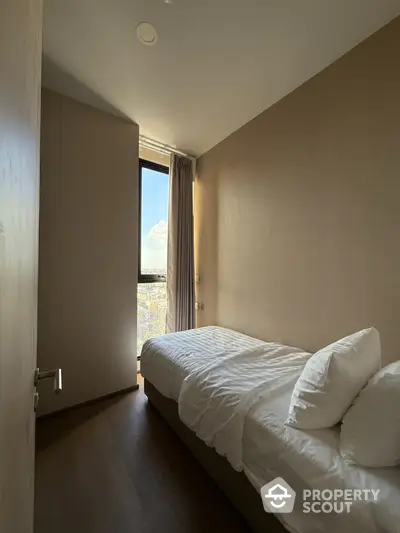 Cozy minimalist bedroom with large window and natural light