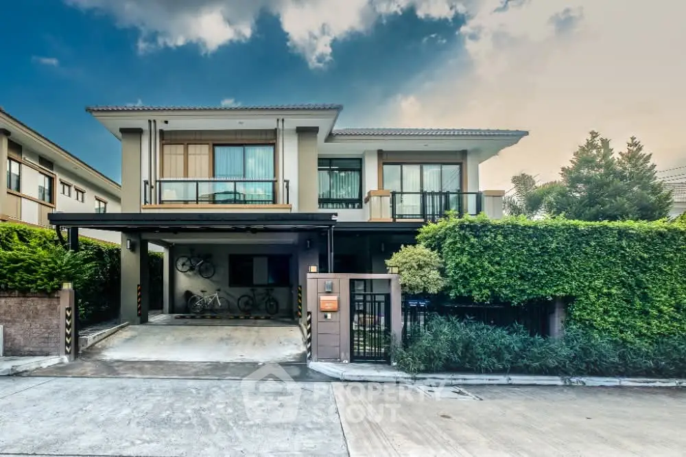 Modern two-story house with lush greenery and spacious driveway