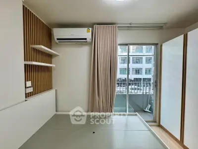 Modern bedroom with air conditioning and balcony access in urban apartment