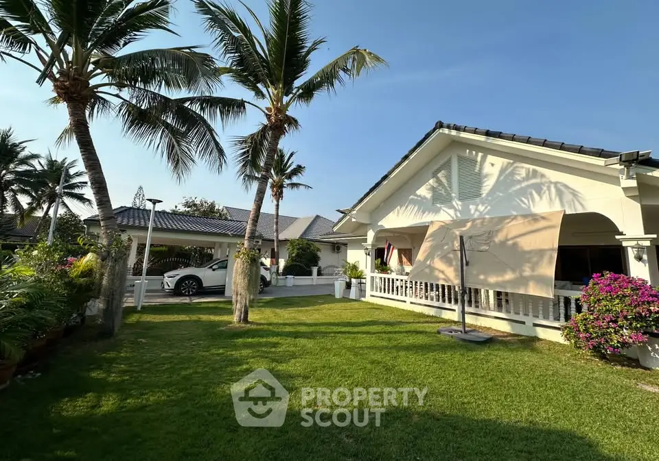 Charming tropical house with lush garden and carport, perfect for serene living.