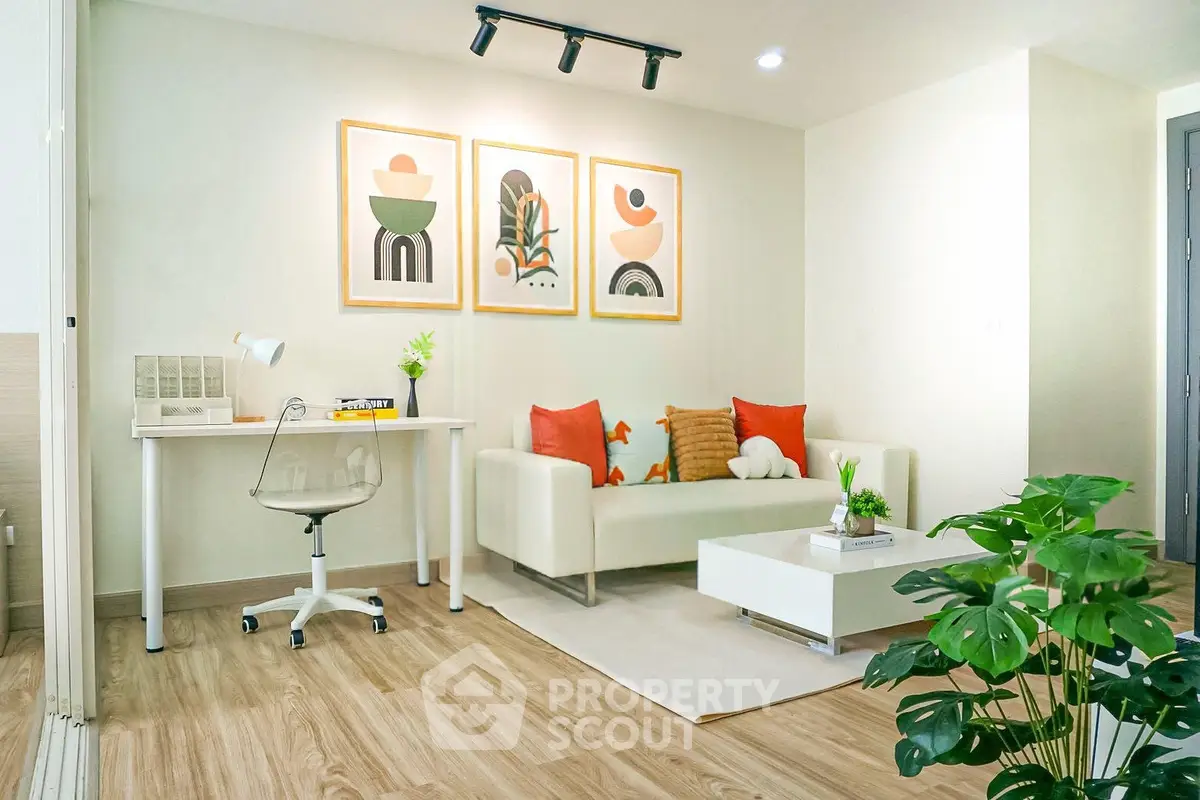 Modern living room with stylish decor and natural light, featuring a cozy sofa and a sleek desk area.