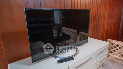 Modern living room with sleek TV setup and stylish wooden paneling