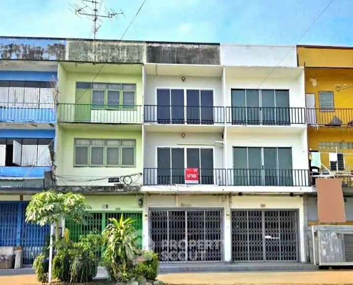 Charming multi-story building with modern facade and spacious balconies in vibrant neighborhood.