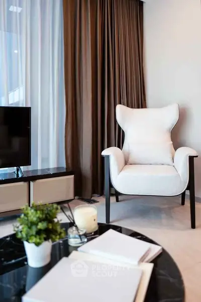 Modern living room with stylish armchair and TV, perfect for relaxation and entertainment.