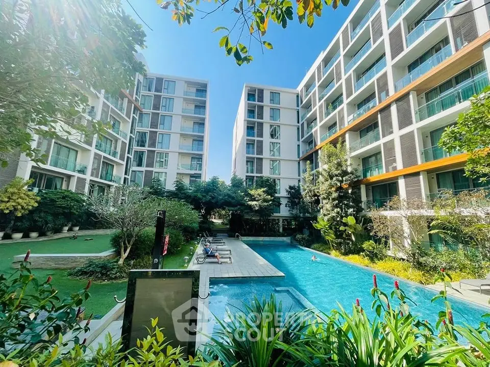 Luxurious residential complex with pool and lush garden view.