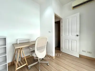Modern study room with minimalist desk and chair, featuring sleek wooden flooring and bright white walls.
