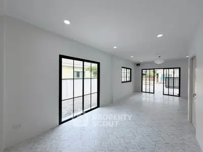 Spacious modern living room with large windows and sleek tile flooring