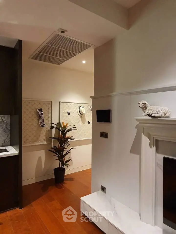 Stylish interior with modern decor and wooden flooring, featuring a cozy fireplace and elegant wall art.