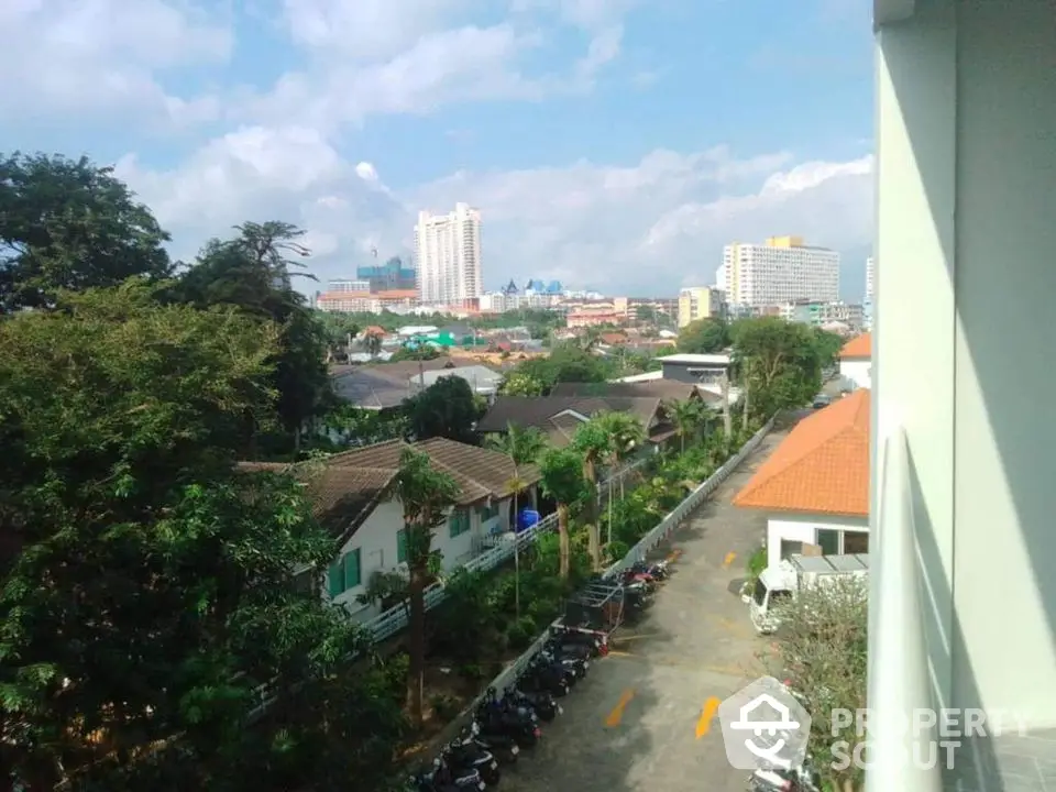 Stunning cityscape view from balcony with lush greenery and skyline