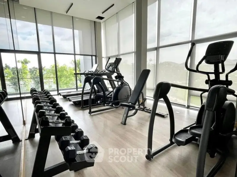 Modern gym with state-of-the-art equipment and large windows offering scenic views.