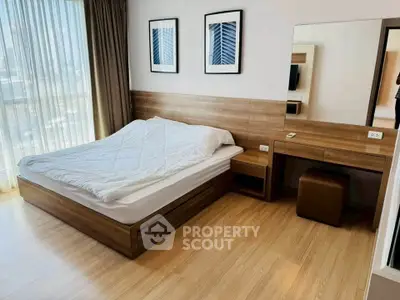 Modern bedroom with wooden flooring and stylish furniture in a bright apartment.