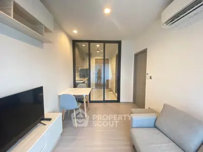Modern living room with sleek furniture and open kitchen layout in a stylish apartment.