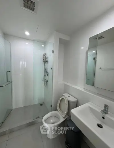 Modern bathroom with glass shower and sleek fixtures in a contemporary apartment.