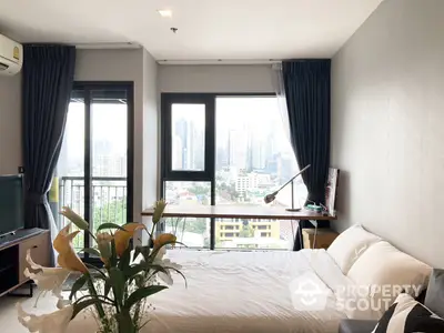 Bright and airy bedroom with a large window offering a stunning cityscape view, complemented by dark curtains and modern furnishings.