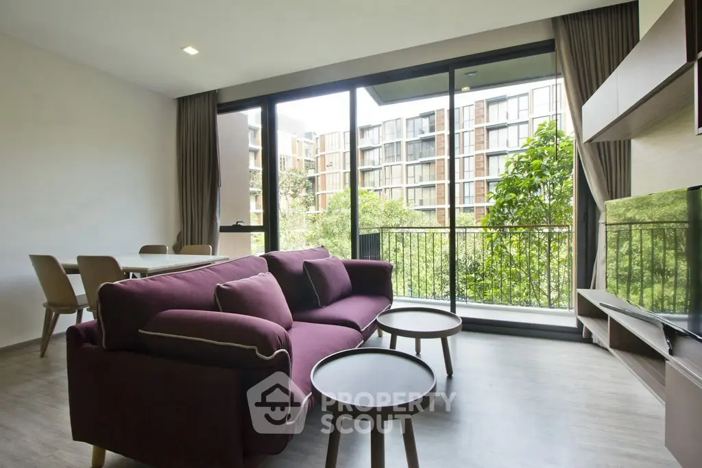 Modern living room with large windows and balcony view in a stylish apartment.