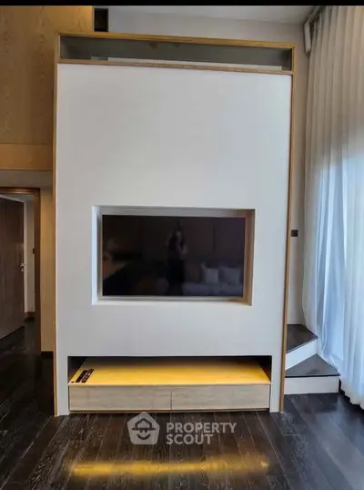 Modern living room with built-in TV and elegant wooden flooring