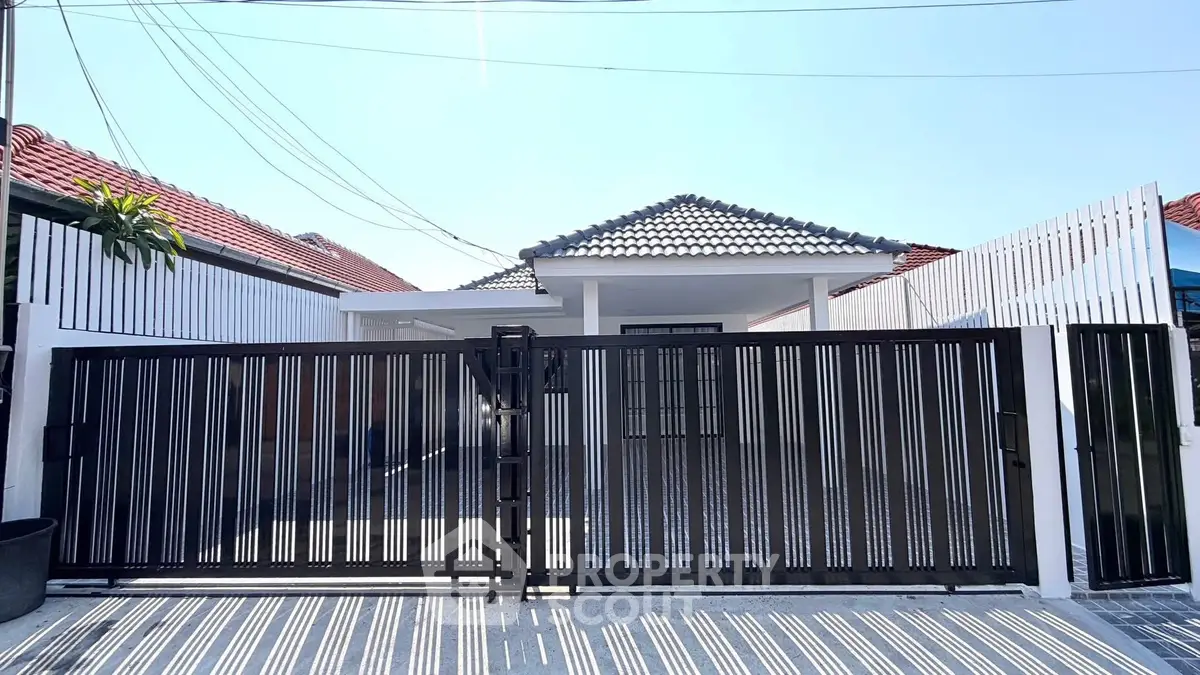 Charming single-story home with modern gate and tiled roof, perfect for family living.