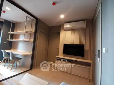 Modern living room with sleek design, featuring built-in TV unit and stylish workspace.