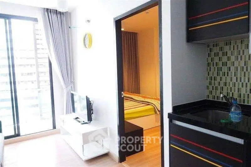 Modern apartment interior with open living room and kitchen, featuring a balcony view and stylish decor.