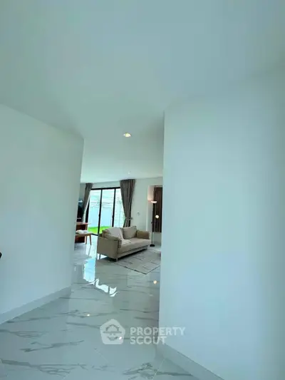 Spacious modern living room with elegant marble flooring and large windows for natural light.